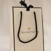 Luxury branded paper bag with black rope handles and ribbon detail