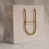Luxury branded paper bag with gold rope handles for cosmetics and beauty retail